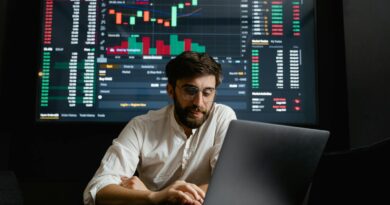 Male analyst studies cryptocurrency trends at a workstation with multiple displays showing market data.