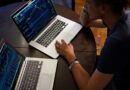 man sitting in front of the MacBook Pro