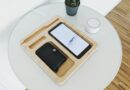 black smartphone with wallet on wooden tray on table