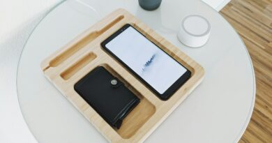 black smartphone with wallet on wooden tray on table