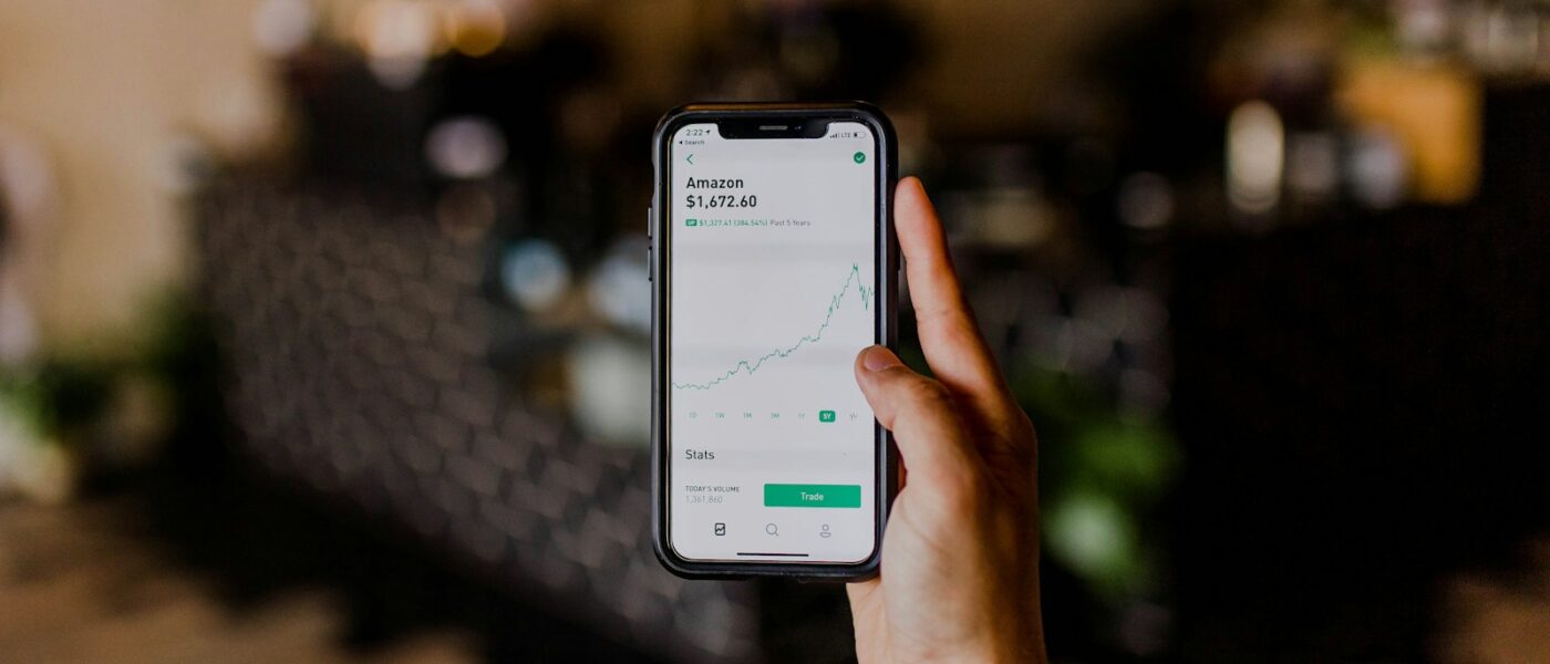 person holding black iPhone displaying stock exchange