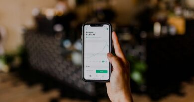 person holding black iPhone displaying stock exchange