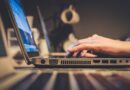 person using silver laptop computer on desk