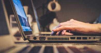 person using silver laptop computer on desk