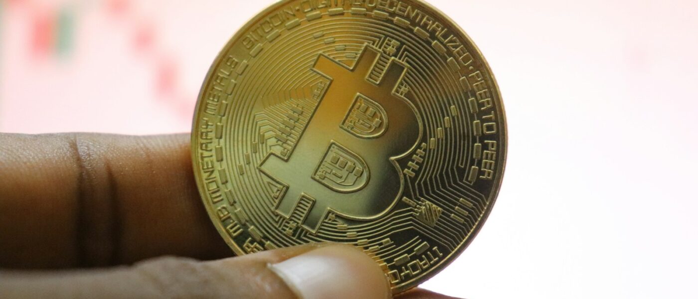 a person holding a bit coin in their hand