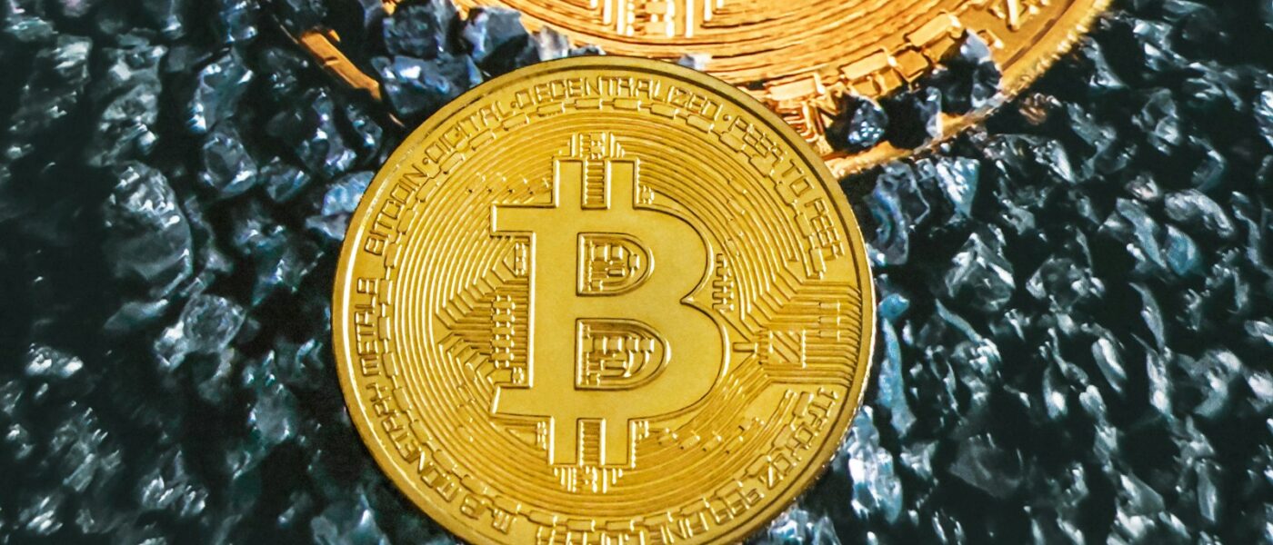 two gold bitcoins sitting on top of each other