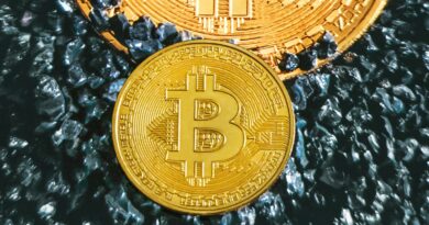 two gold bitcoins sitting on top of each other