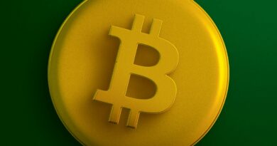 a yellow bit coin sitting on top of a green surface