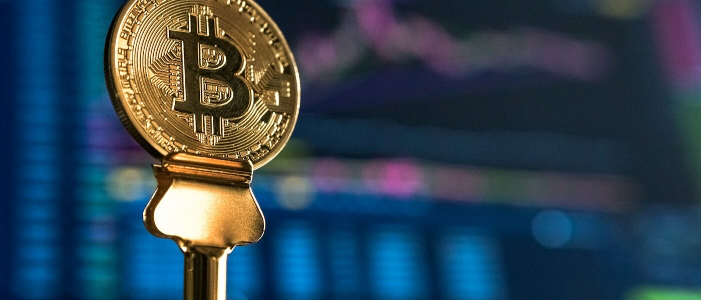 selective focus photo of Bitcoin near monitor