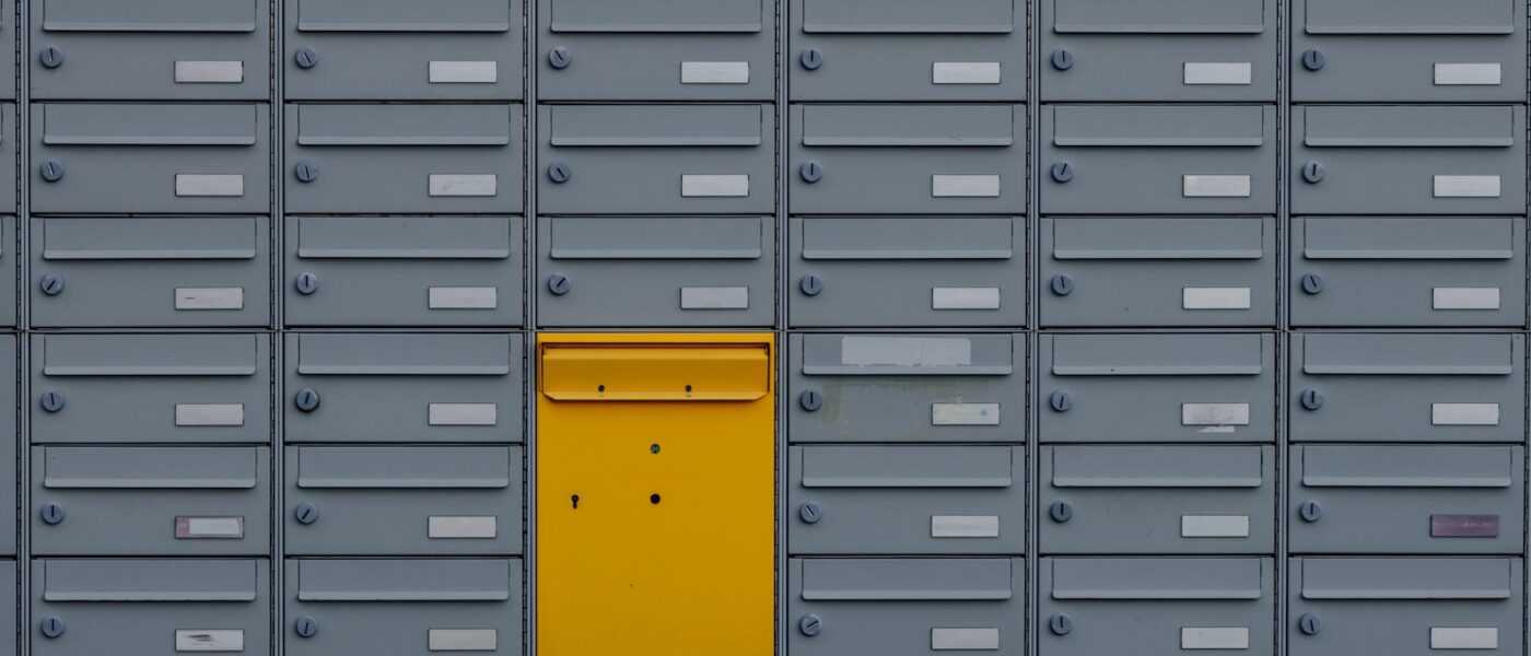 a bunch of mail boxes with a yellow door