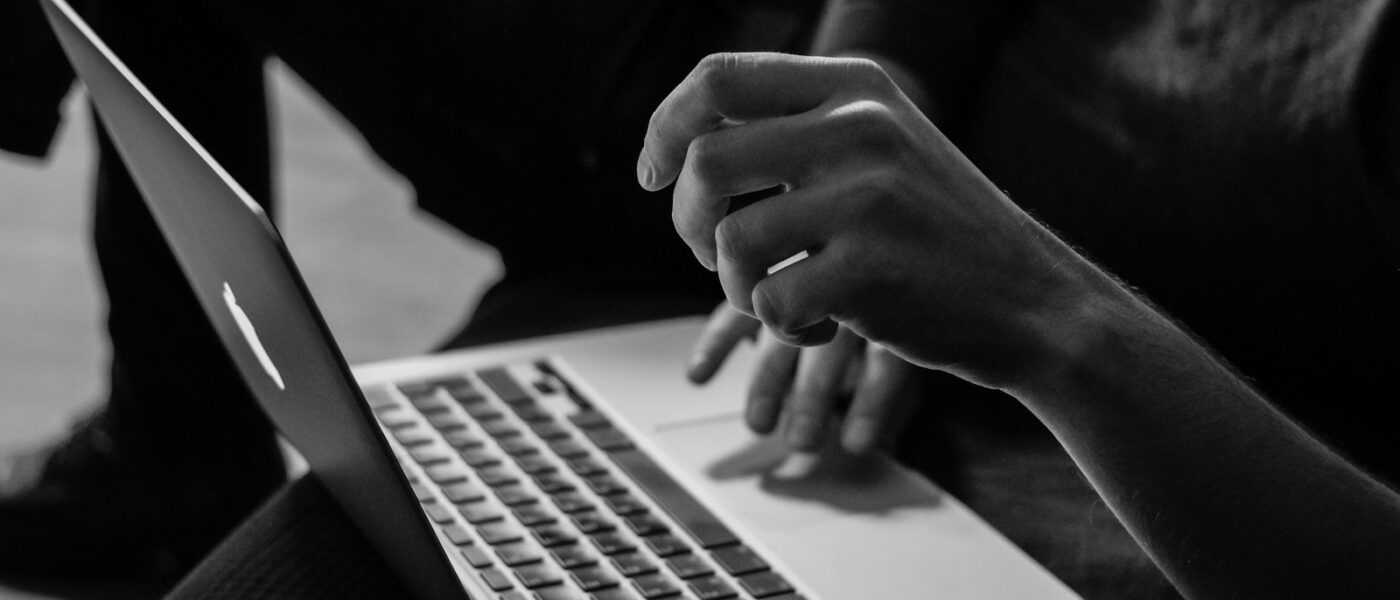grayscale photo of person using MacBook