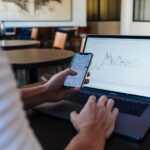 person using smartphone and MacBook Pro