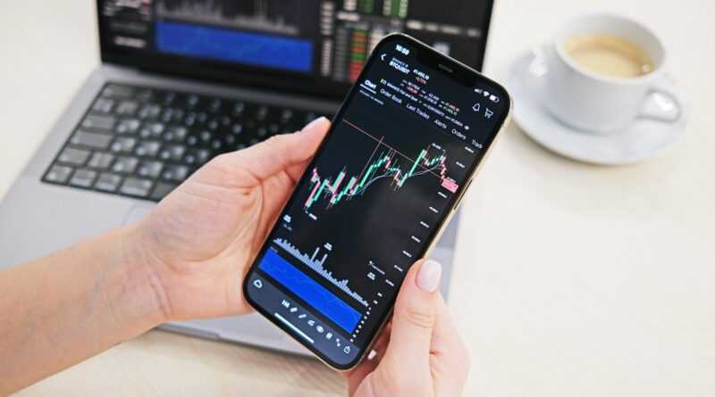 a person holding a cell phone in front of a laptop