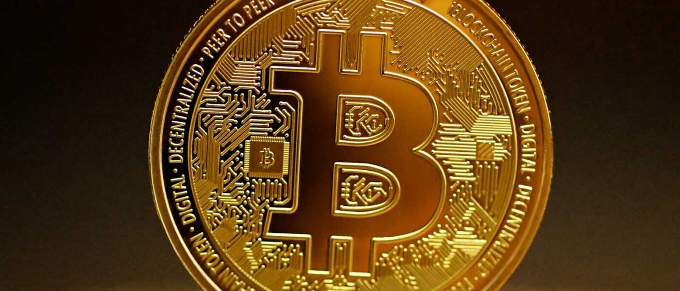 a golden bitcoin sitting on top of a table